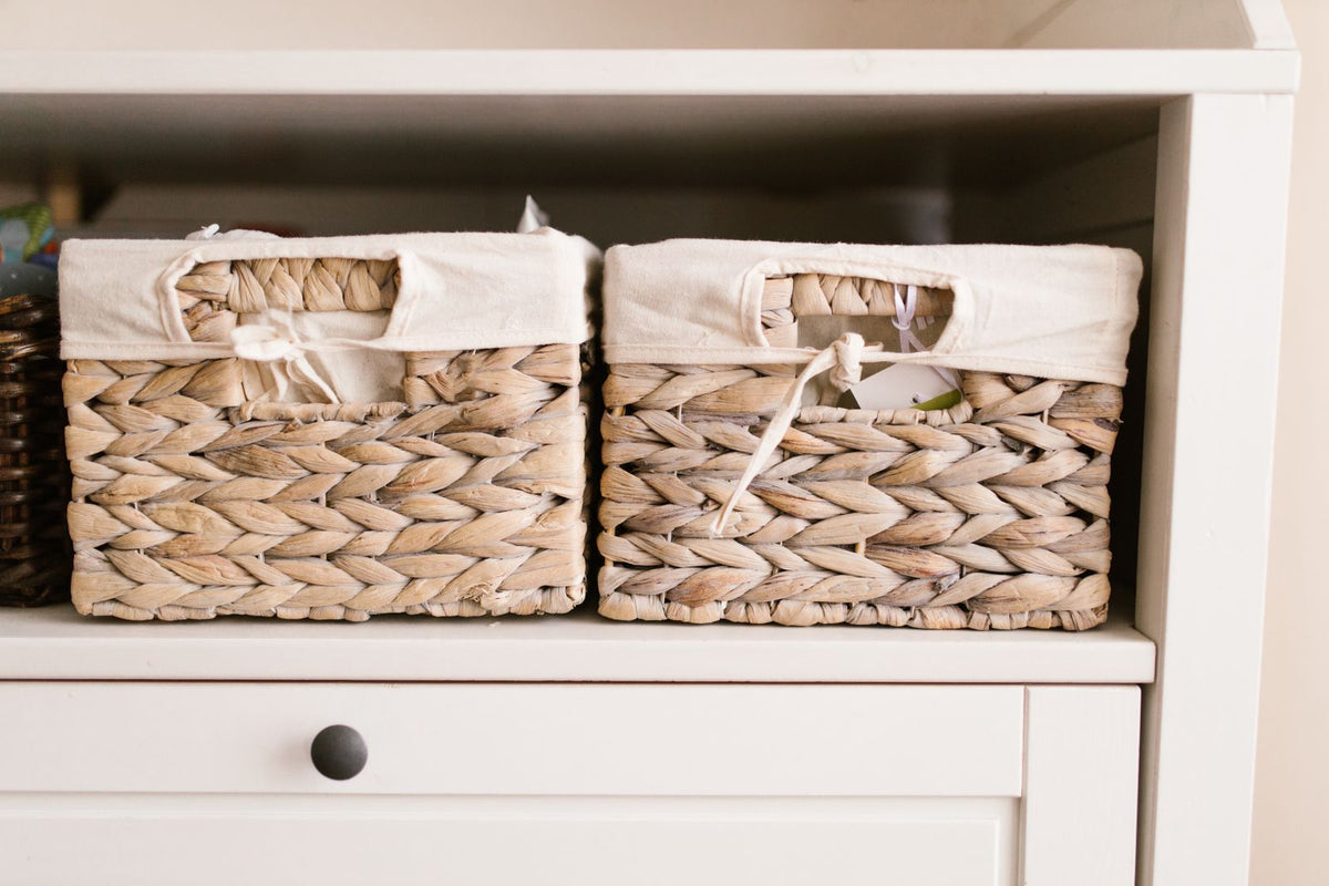 Woven storage baskets neatly arranged on a white shelf